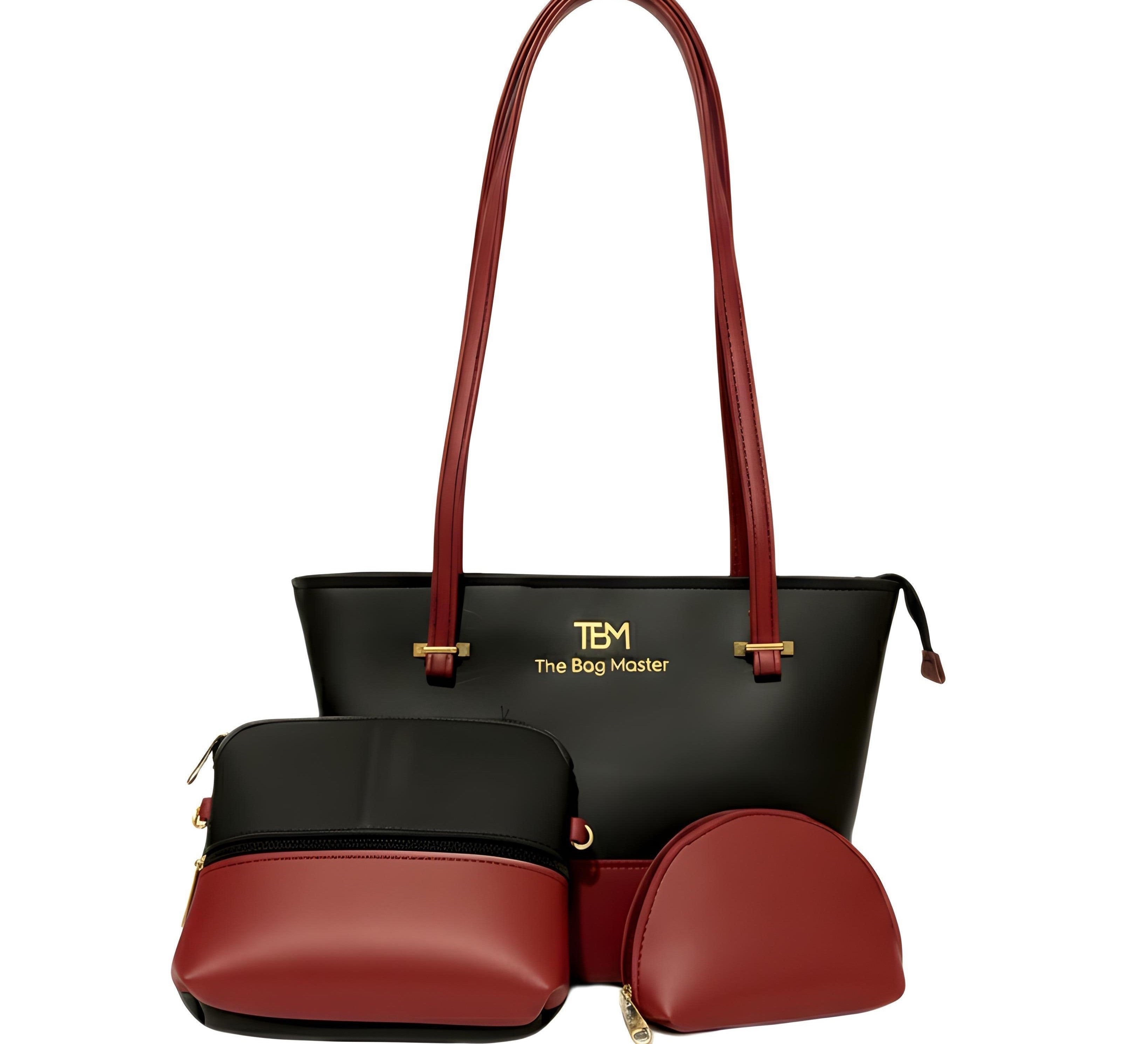 Sleek black and maroon tote with maroon straps labeled "TBM - The Bag Master," with matching pouch and half-moon clutch on a white background.